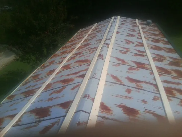 Rusted metal roof panels with new wood purlins before replacement — Storm Damage Roof Repair in Many by Roofing Brothers