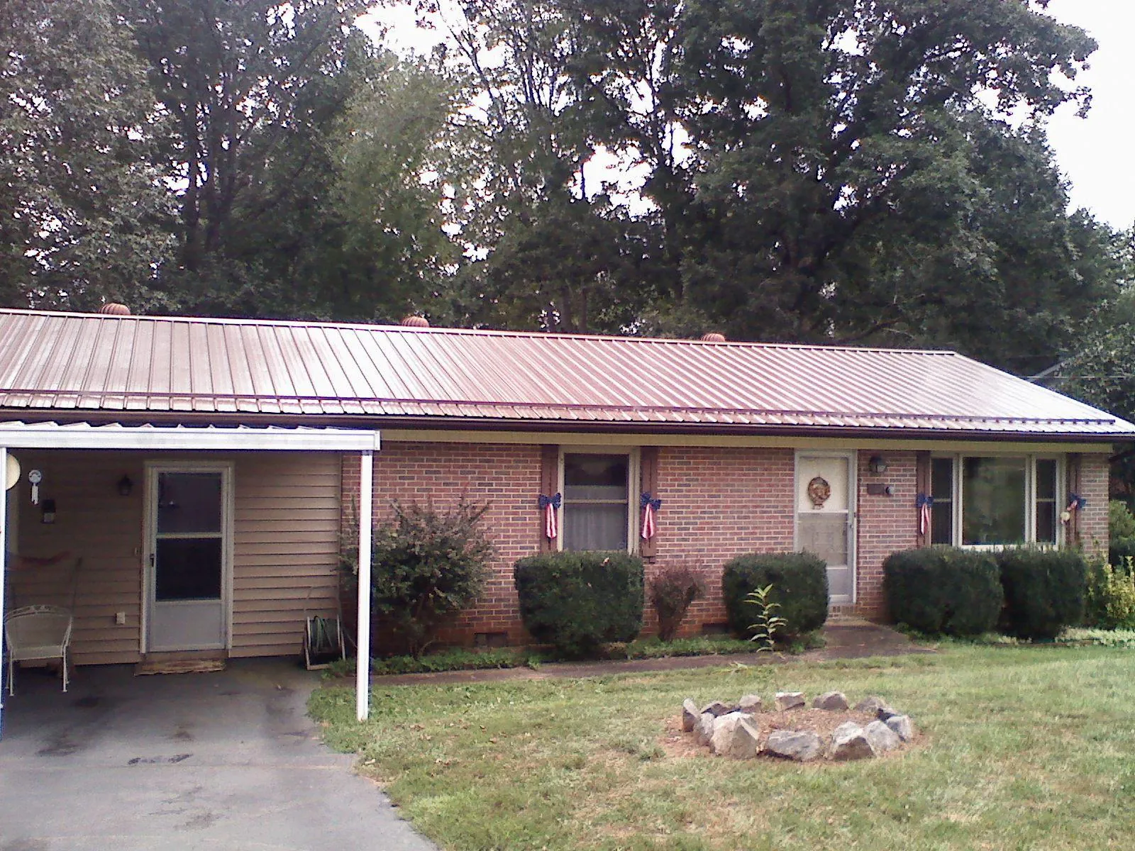 Bronze metal roof and carport on a brick ranch home — Roof Repair work by our crew in Many