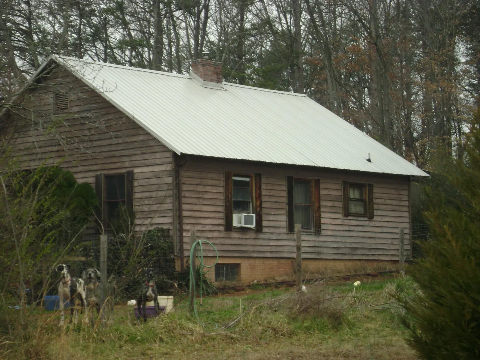 White metal roof on an old wood sided farmhouse, from a Metal Roof Installation job in Many
